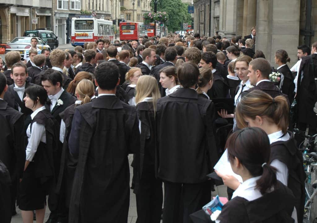 Oxford, England students in class uniforms and black gowns.