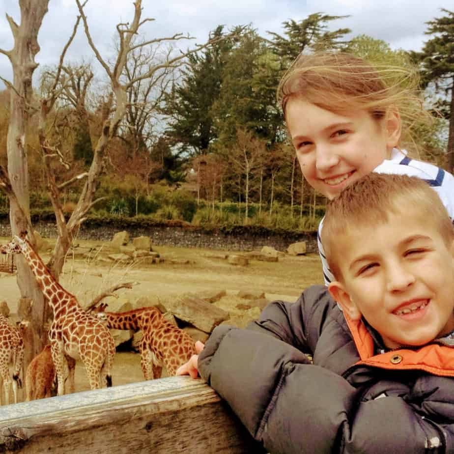 Image of 2 kids at Dublin Zoo enjoying the giraffes.