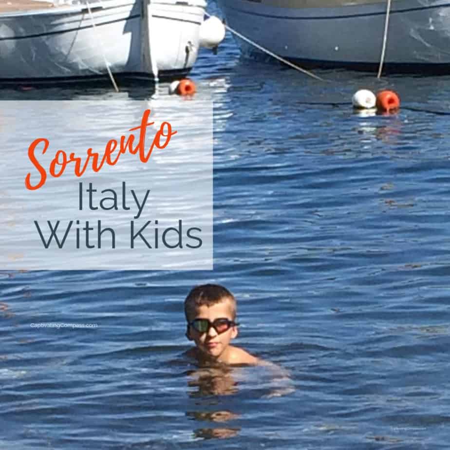 Image of boy wearing goggles swimming in Mediterranean Sea with text overlay Sorrento with Kids