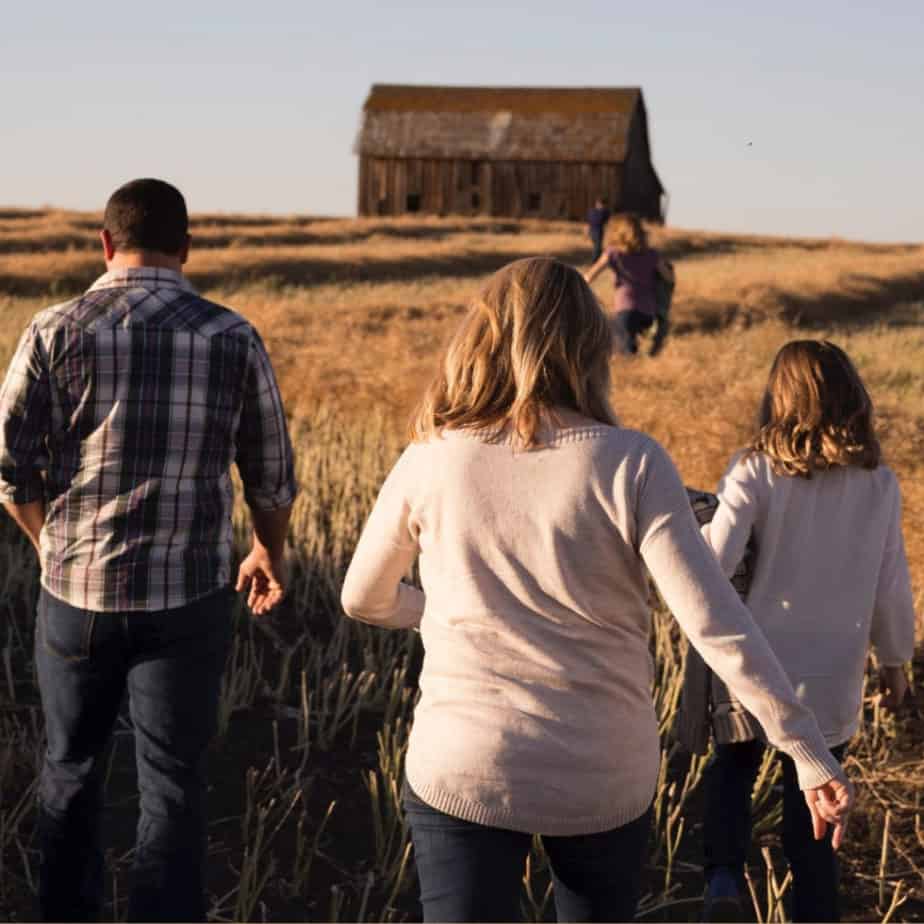 Image of familyy walking through field toward barn