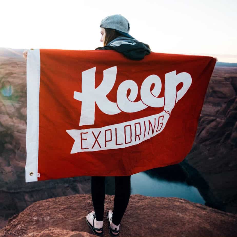 image of woman holding banner that says'Keep Exploring'