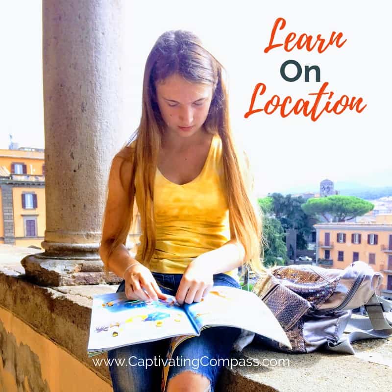 image of girl sitting on italian wall doing homework with text overlay Learn On Location with www.captivatingcompass.com