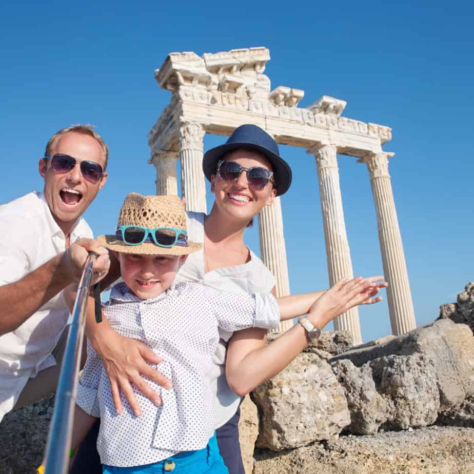 image of family taking selfie infron of greek temple. Intentional family travel resources at www.captivatingcompass.com