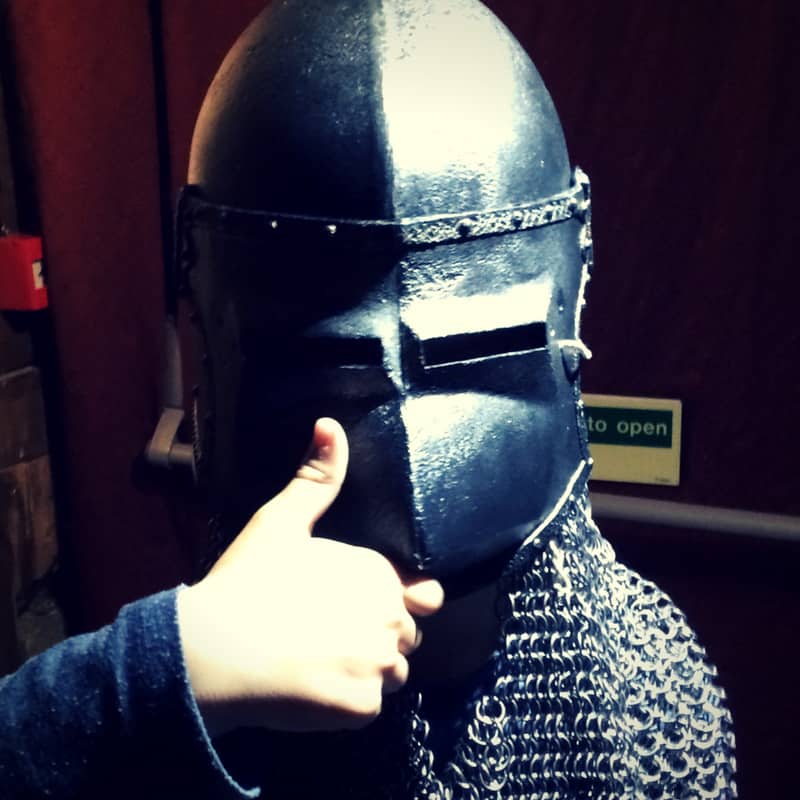 image of boy giving thumbs up wiearing medieval helmet and chain mail at www.captivatingcompass.com